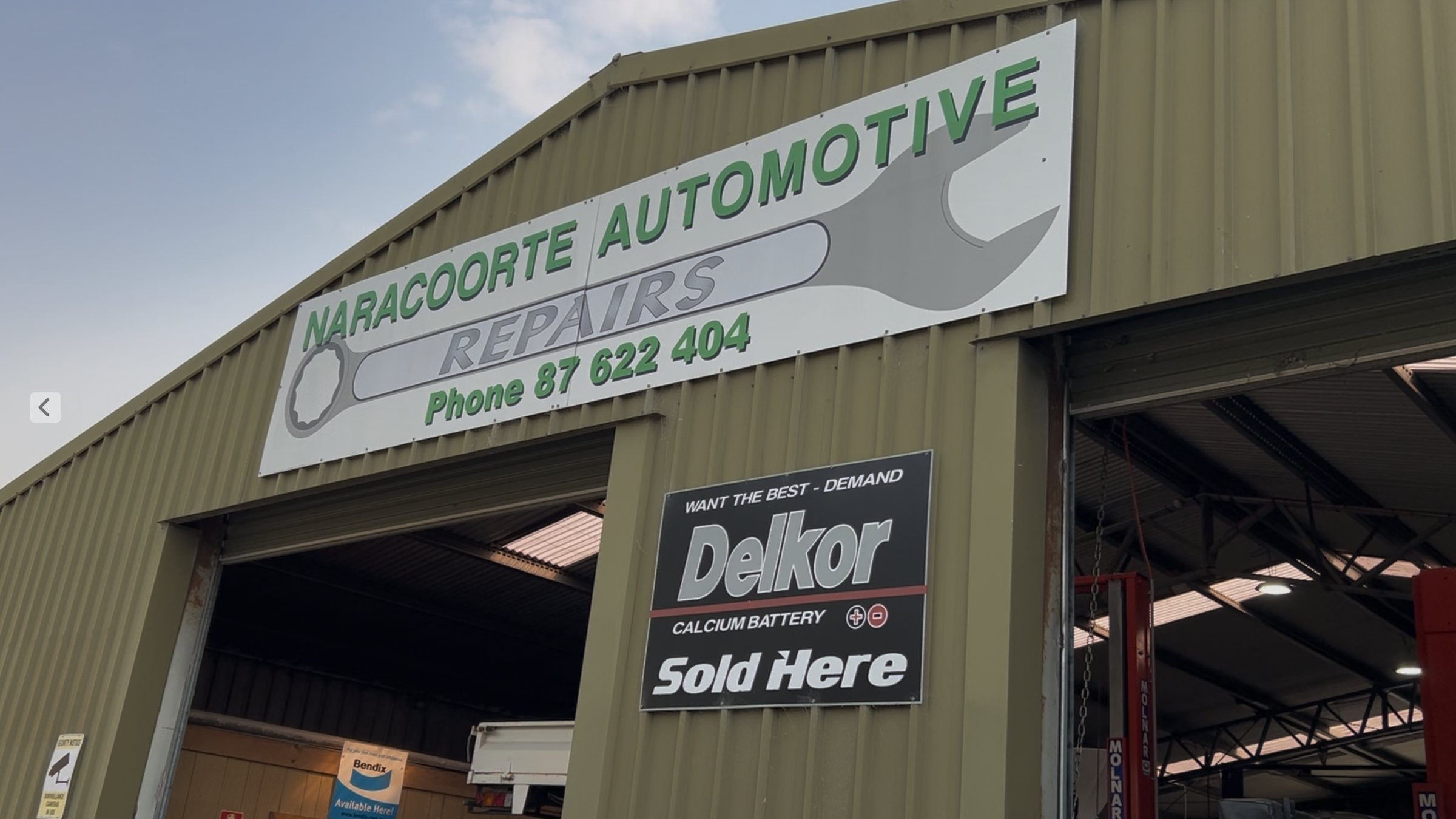 The front of the Naracoorte Automotive Repairs shed on Butler Terrace, roller door open, with Delkor and Bendix signs beside it