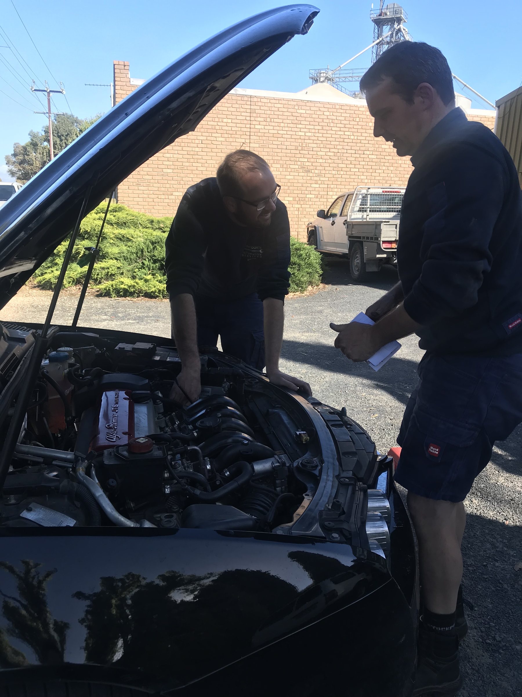 Two of the team looking over an engine bay outside the Naracoorte workshop