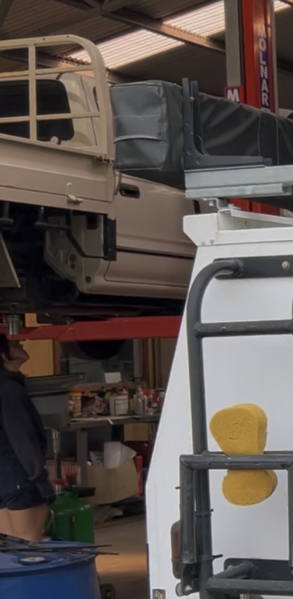 Inside the Naracoorte Automotive Repairs workshop, with a loaded four wheel drive canopy rig and a second ute up on a hoist